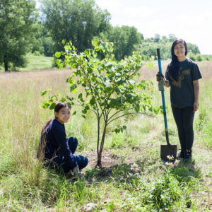 two girls planting tree